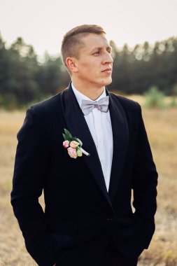 Siyah smokin bir papyon ile yakışıklı damat portresi.