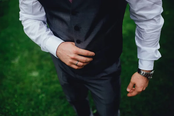 Detaljerad närbild foto av en vacker brudgum i en grå kostym med — Stockfoto