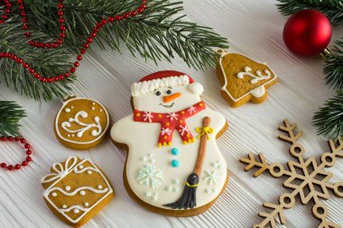 Beyaz ahşap zemin üzerinde gingerbread ile Noel kompozisyon