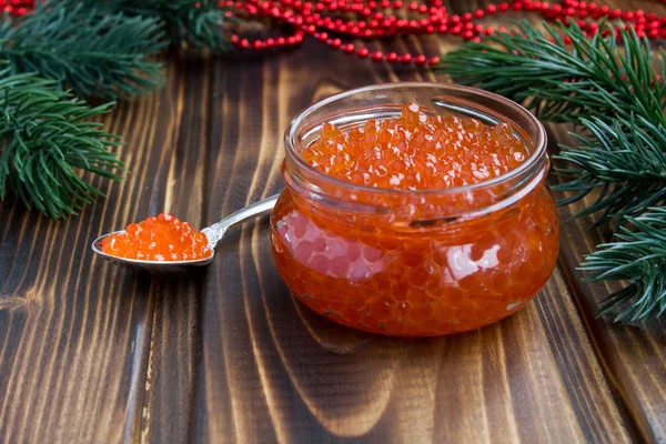 Cam kavanoz ve Noel kompozisyonu ahşap arka plan üzerinde kırmızı havyar