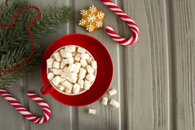 Sıcak kakao marshmallows kırmızı Kupası ve gri ahşap arka plan Christmas kompozisyonu ile. Üstten görünüm. Kopya alanı.
