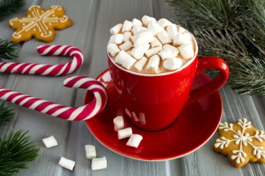 Sıcak kakao marshmallows kırmızı Kupası ve gri ahşap arka plan Christmas kompozisyonu ile