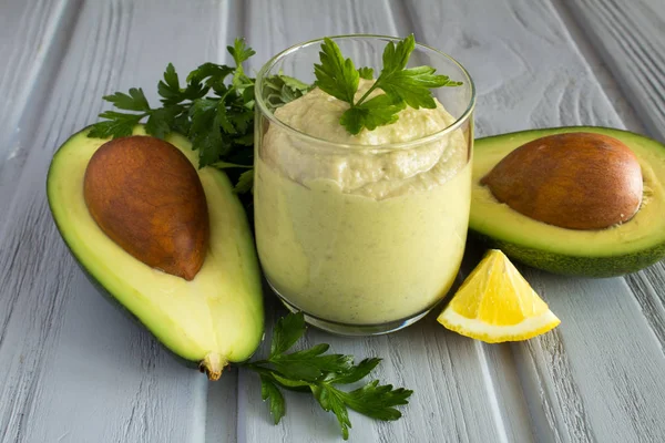 Smoothie with avocado and parsley on the grey wooden background