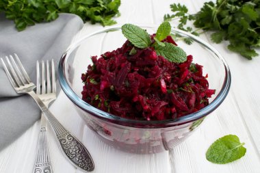 Rendelenmiş pancar ve otlar Beyaz ahşap zemin üzerinde cam kase salata