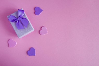 Menekşe yay ve pembe kalpler ile Hediyelik kullanır. Üstten görünüm. Kopya alanı.