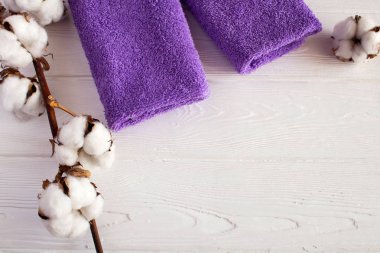 Şube cottton ve menekşe havlu Beyaz ahşap zemin üzerinde. Üstten görünüm.
