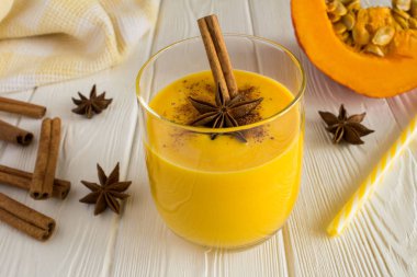 Kabak, tarçın ve anason Beyaz ahşap zemin üzerinde süt smoothies