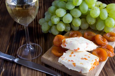 Kuru Kayısı, kadeh şarap ve meyve ahşap arka plan üzerinde yumuşak peynir