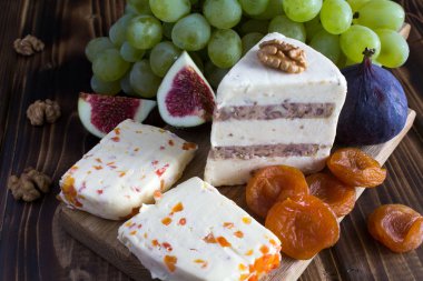 Yumuşak peynir ve meyve ahşap kesme tahtası üzerinde