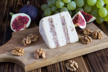 Fındık ve ahşap kesme tahtası üzerinde meyve yumuşak peynir
