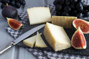 Peynir ve meyve gri kesme tahtası üzerinde parçalar