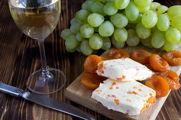 Kuru Kayısı, kadeh şarap ve meyve ahşap arka plan üzerinde yumuşak peynir