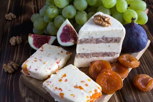 Yumuşak peynir ve meyve ahşap kesme tahtası üzerinde