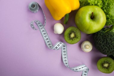 Sebze, meyve ve mor zemin üzerine beyaz santimetre. Sağlıklı gıda maddeleri. Üstten görünüm. Kopya alanı.