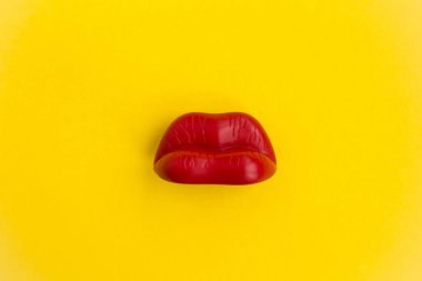 Sarı zemin üzerine kırmızı dudaklar. Üstten görünüm. Kopya alanı.