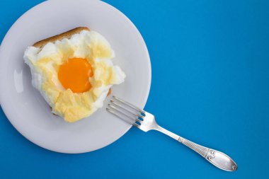 İçinde belgili tanımlık bulut mavi zemin üzerine beyaz tabakta yumurta ile sandviç. Üstten görünüm. Kopya alanı.