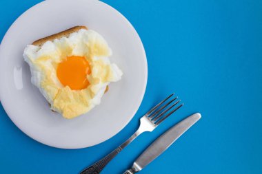 İçinde belgili tanımlık bulut mavi zemin üzerine beyaz tabakta yumurta ile sandviç. Üstten görünüm. Kopya alanı.