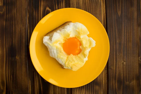 Yumurta içinde belgili tanımlık bulut kahverengi ahşap zemin üzerine sarı plaka ile sandviç. Üstten görünüm. Kopya alanı.