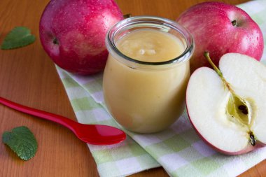 Elma püresi kavanoz ve masada kırmızı elmalar