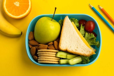 Okul yemeği kutusundaki sarı arka plan üzerinde. Üstten görünüm.