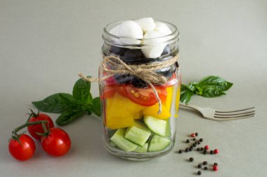 Gri arka plan üzerinde cam kavanoza Yunan salatası