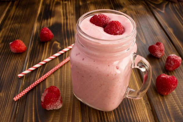 Smoothies with yogurt  and frozen strawberry on the  brown wooden background