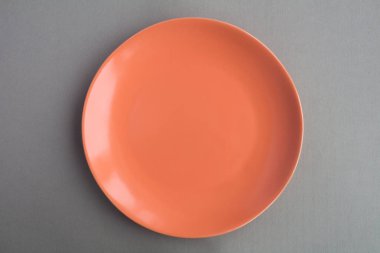 Boş mercan plaka gri arka plan üzerinde renkli. Üstten görünüm. Uzay kopyalayın. Diyet en az kavramı.