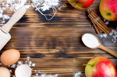 Elmalı turta kahverengi ahşap zemin üzerinde pişirme için malzemeler. Üstten görünüm. Kopya alanı.