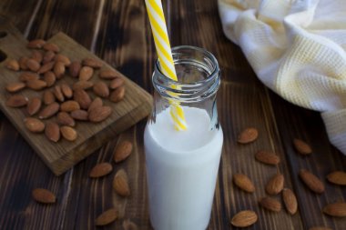 Kahverengi ahşap zemin üzerinde cam şişe badem sütü