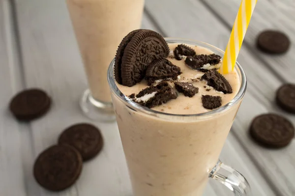 Milkshake with chocolate biscuit  and cocoa in the glass on the grey wooden  background.Closeup.