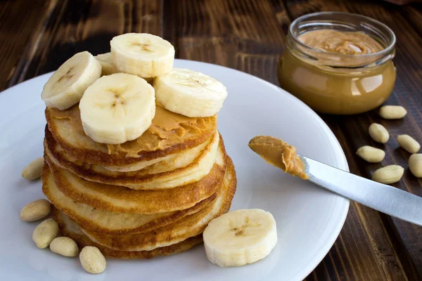 Homemade Pancakes Peanut Paste Banana White Plate Brown Wooden Background — Stock Photo, Image
