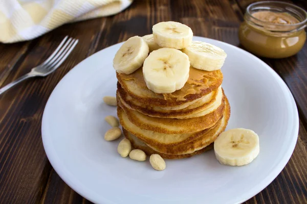 Homemade Pancakes Peanut Paste Banana White Plate Brown Wooden Background — Stock Photo, Image