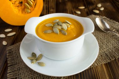 Rustik ahşap arka plan üzerinde beyaz tabak kabak çorbası