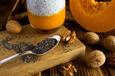 Kaşık, kabak ve ceviz kahverengi ahşap zemin üzerine puding Chia tohum