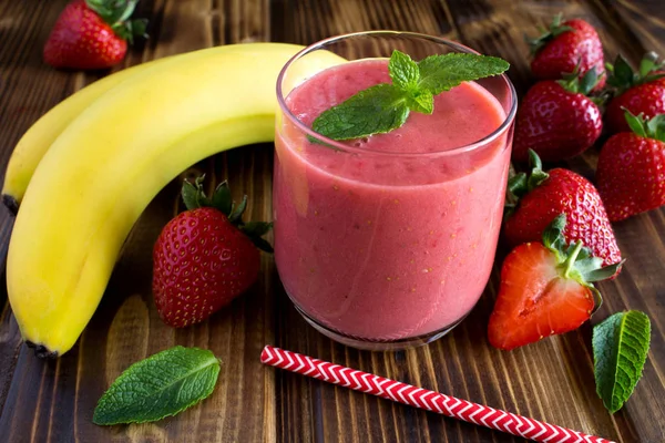 Smoothie  from strawberry and banana on the   brown wooden background