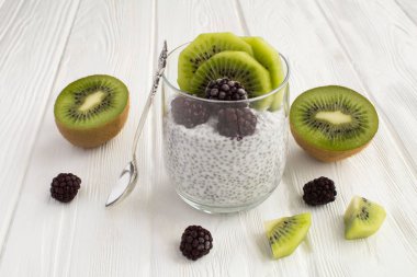 Chia, kivi ve blackberry Beyaz ahşap zemin üzerine puding