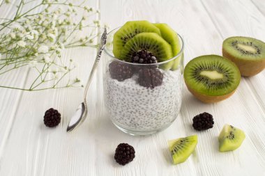 Chia, kivi ve blackberry Beyaz ahşap zemin üzerine puding