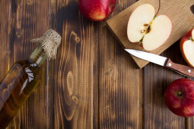 Kahverengi ahşap zemin üzerinde cam şişede elma sirkesi. Üstten Görünüm. Kopya alanı.