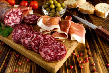 İspanyol jamon ve kahverengi ahşap zemin üzerinde kesme tahtası sosis