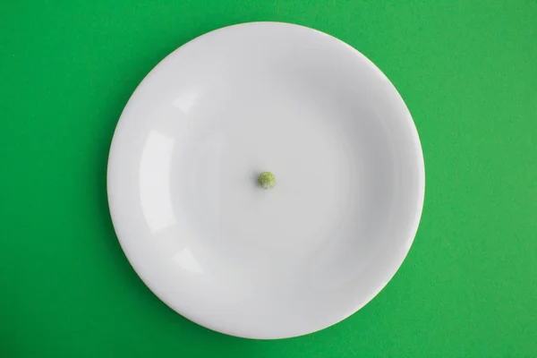 Ένα Πράσινο Μπιζέλι Στο Άσπρο Πιάτο Στο Πράσινο Φόντο Top — Φωτογραφία Αρχείου