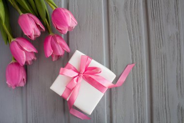 Pembe fiyonk ve gri ahşap arka plan üzerinde Pembe Lale ile Hediyelik kullanır. Üstten Görünüm. Kopya alanı.