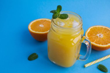 Portakal suyu buz cam üzerinde mavi arka plan ile. Kopya alanı.