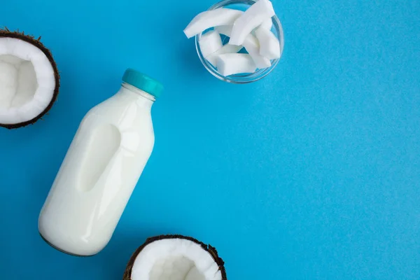 Coconut  milk in the glass bottle on the blue background.Top view.Copy space.