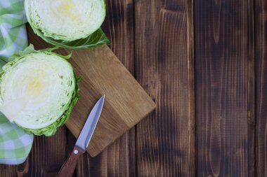 Kıyılmış lahana kahverengi ahşap zemin üzerinde kesme tahtası üzerinde. Üstten Görünüm. Kopya alanı.