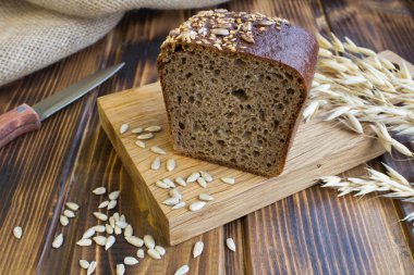 Kahverengi ahşap zemin üzerinde kesme tahtası üzerinde ev yapımı ekmek dilimlenmiş