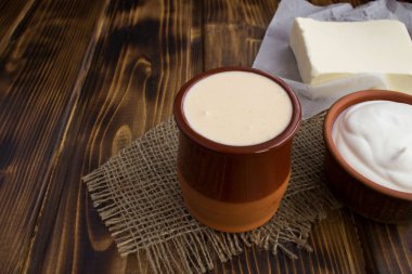 Ev yapımı ryazhenka, ekşi krema ve tereyağı rustik arka plan üzerinde. Fermente süt ürünleri.