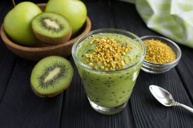 Smoothies kivi, yeşil elma ve arı polen siyah ahşap zemin üzerine