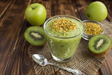 Kivi, yeşil elma ve rustik ahşap arka plan üzerinde arı polen ile smoothies
