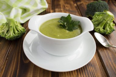 Vejetaryen brokoli püre çorbası inci beyaz kase kahverengi ahşap zemin üzerinde