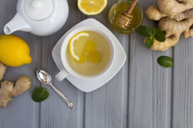 Gri ahşap arka planda zencefil çayı ve malzemeler. Üst görünüm. Boşluk Kopyala.